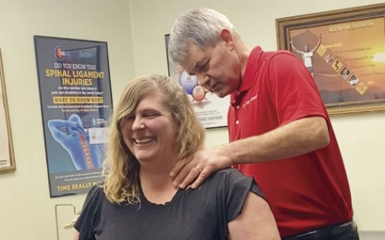 Chiropractor Burley ID Troy Crane Training row Dr. Crane applies pressure to a patient’s shoulder area during a seated manual therapy session.